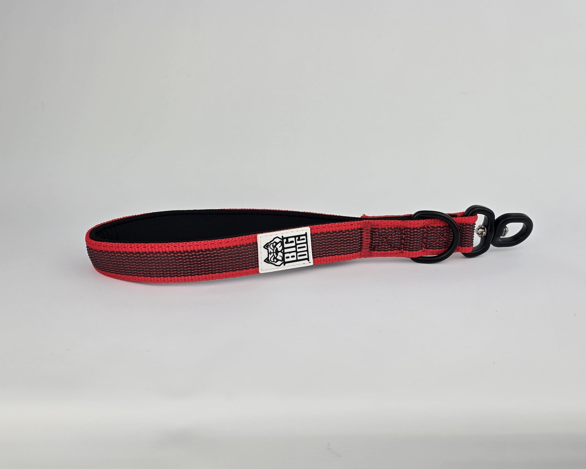 Red and black dog handle with a The Big Dog Company logo. Neoprene, rubber, nylon. Heavy duty, high quality. 
